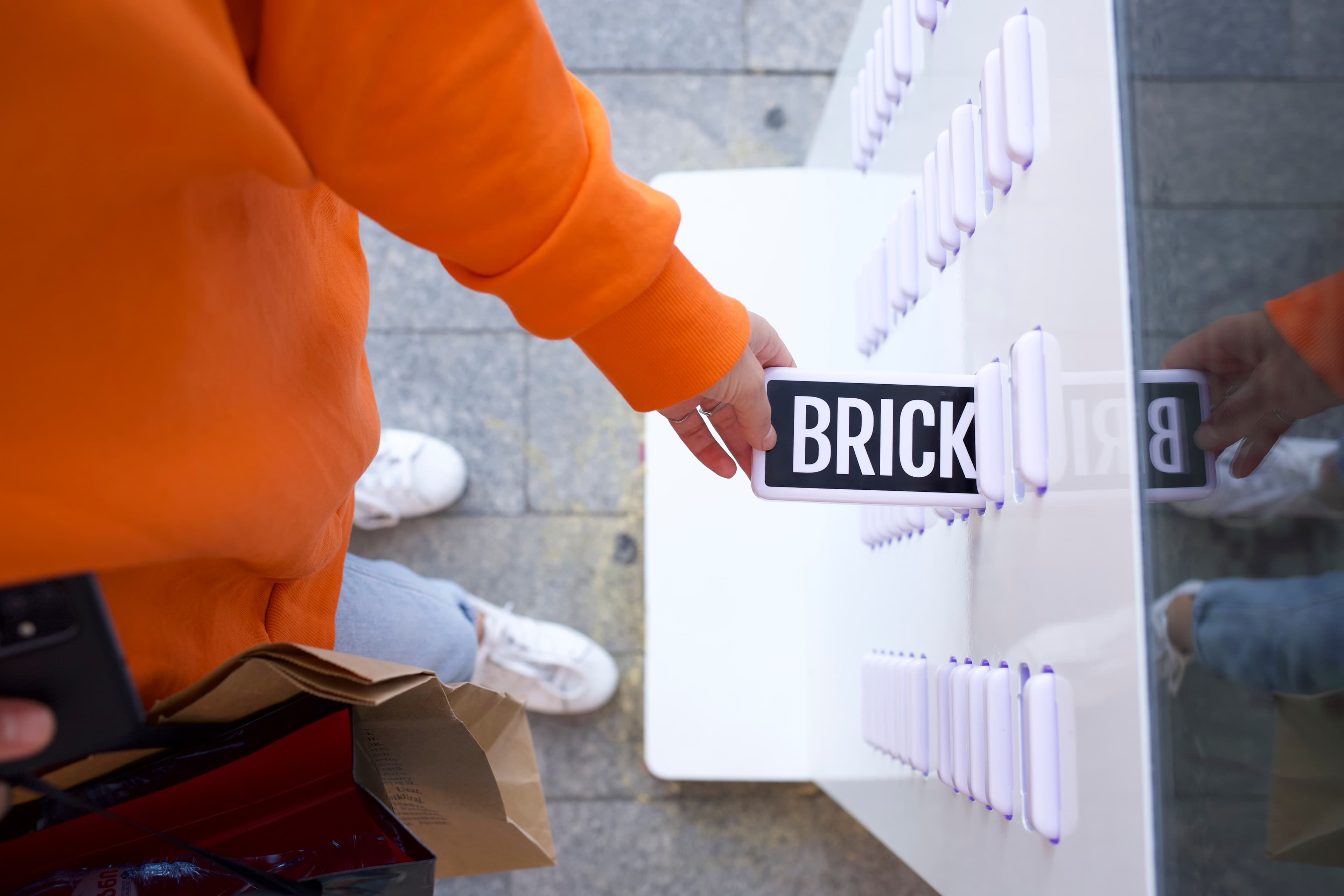 Una mano sacando un banco de energía Brick de una estación